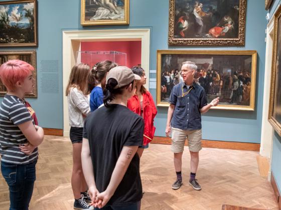 一个班在博物馆的画廊里开会.